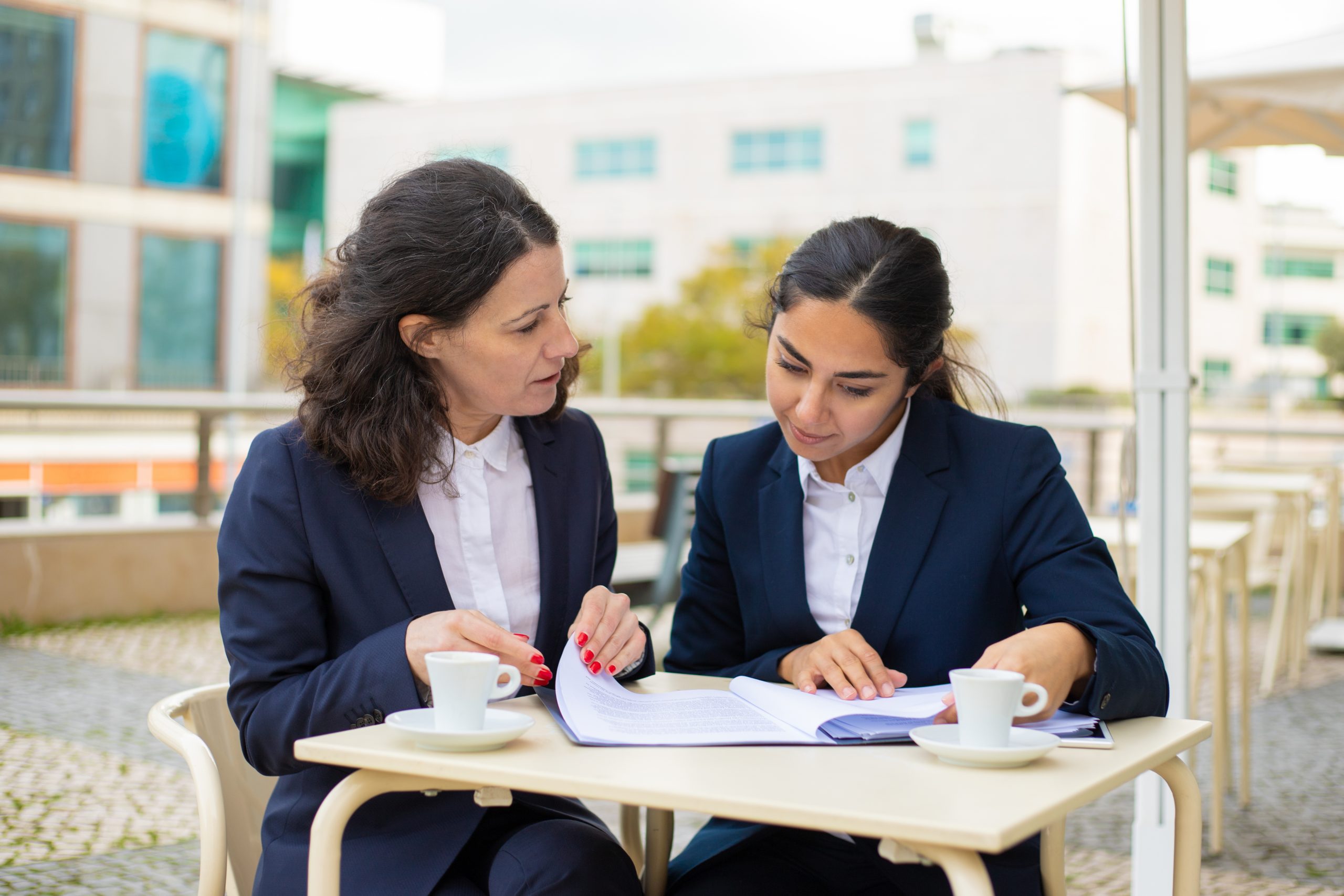 Businesswomen working with papers in outdoor cafe Digital Nest, Digital Nest School of Business